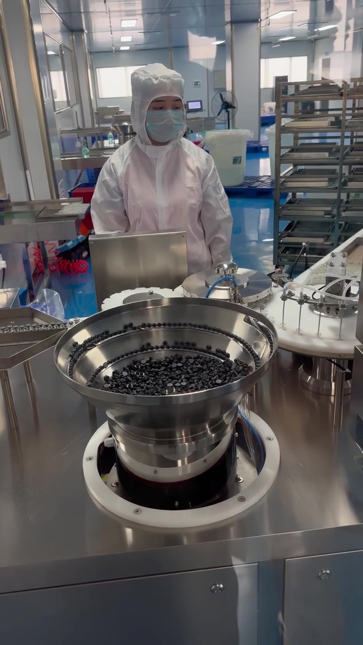 Supplied view of personnel working with vial-handling equipment